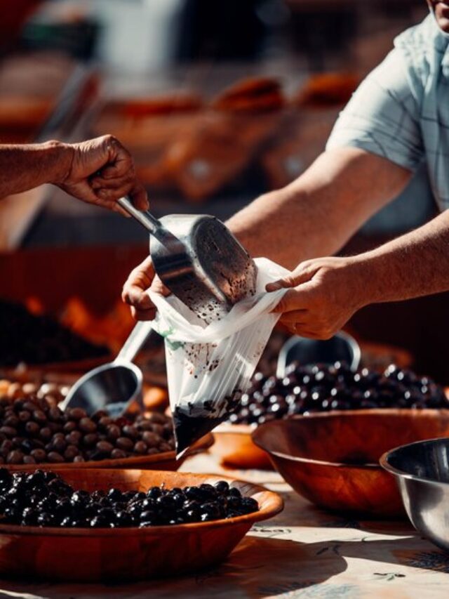 closeup-shot-customer-buying-olive-taking-it-plastic-case-from-seller_181624-60310